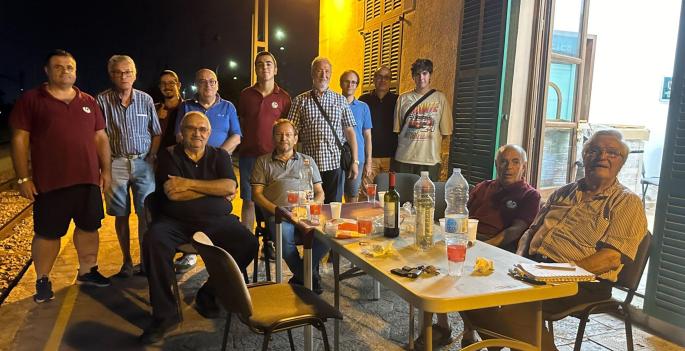 Die Mitglieder des Vereins der Eisenbahnfreunde, wie sie den Abend mit Gemüse-Coca und Wein am Bahnhof von Son Sardina ausklingen lassen. Dabei vorne links in dunkler Kleidung: Präsident Miquel Ëngel Riera.