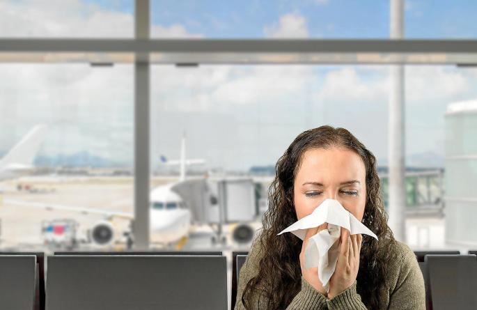 Niesende Frau auf Flughafen.
