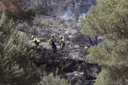 Feuerwehrmänner halten nach weiteren Brandherden in der Nähe von Costa del Pins Ausschau