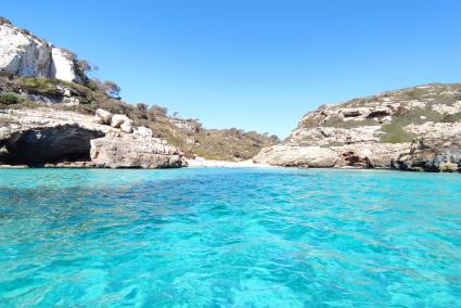 Die entlegene Cala Marmols leuchtet unter dem hellblauen Himmel.