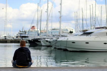 Ein junger Mann genießt den Ausblick am Hafen von Palma.