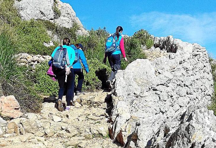 Wanderer steigen bei Ses Voltes d'En Galileu hinauf. 