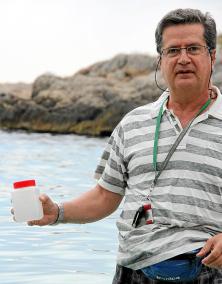 Einer der Kontrolleure des balearischen Gesundheitsministeriums mit Meerwasserprobe am Strand von Illetas.