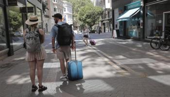 Zwei Touristen mit ihrem Trolley-Koffer auf Mallorca – haben sie Glück mit ihrer Ferienwohnung oder wurden sie Opfer eines Betrugs?